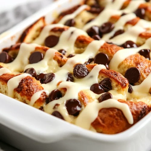 Delicious Chocolate Chip Bagel Casserole Recipe For Breakfast 3 Freshly Baked Chocolate Chip Bagel Casserole Drizzled With Cream Cheese Icing In A White Dish