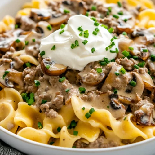 Delicious Ground Beef Stroganoff Noodles For Busy Weeknights 3 Bowl Of Ground Beef Stroganoff Noodles Topped With Sour Cream And Fresh Chives, Warm And Inviting On A White Background.