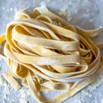 How To Make Homemade Pasta Served In A White Plate, Garnished With Basil And Parmesan Cheese