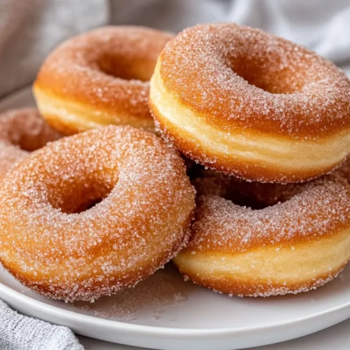 Platter Of Sourdough Doughnuts Glazed And Sprinkled With Cinnamon Sugar, Set On A White Plate