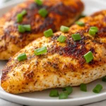 Golden Ranch Chicken Breast On A White Plate, Garnished With Green Onions And Creamy Ranch Sauce